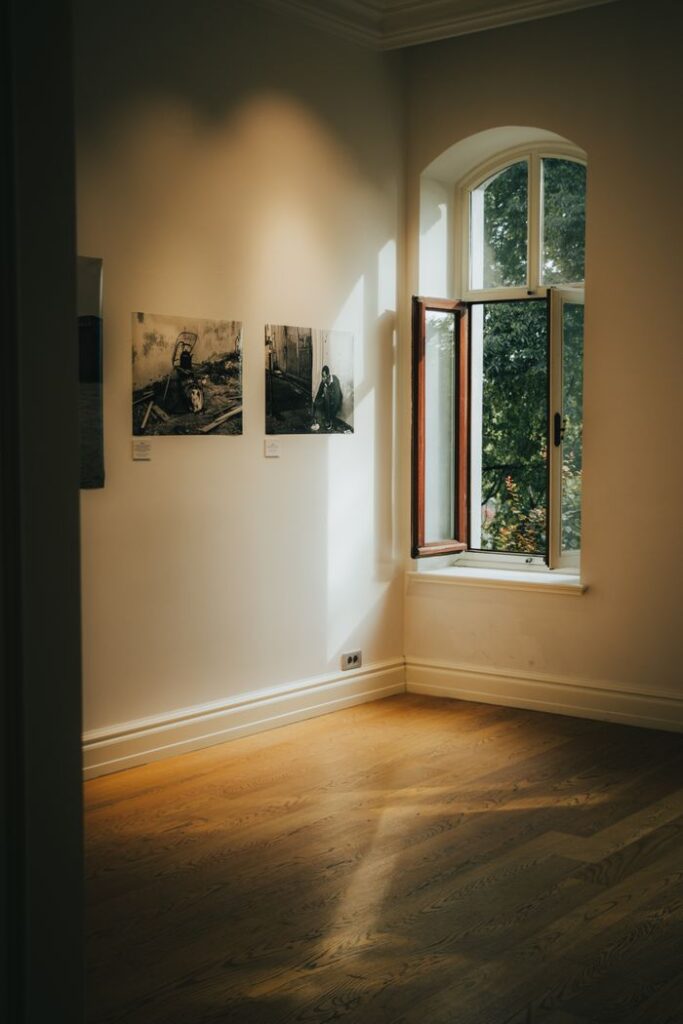 Crafting Captivating Headlines: Your awesome post title goes here Art gallery corner with sunlight through an open window, highlighting framed photographs on a white wall.