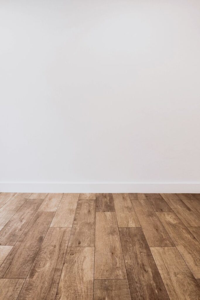 The Art of Drawing Readers In: Your attractive post title goes here Clean white wall with wooden flooring offering versatile copy space.