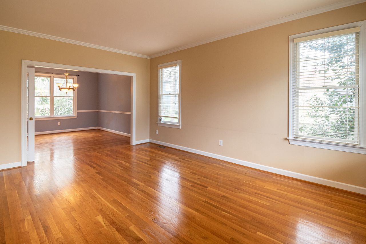 Mastering the First Impression: Your intriguing post title goes here Bright empty room with wooden floors and large windows, ideal for real estate listings.